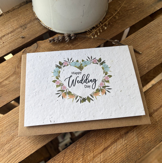 Greeting card with 'Happy Wedding Day' text and floral design on a wooden surface.